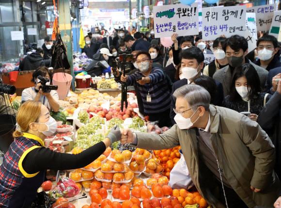 더불어민주당 이재명 대선후보가 20일 충남 논산시 화지중앙시장을 방문, 상인과 인사하고 있다. 2021.11.20  연합뉴스