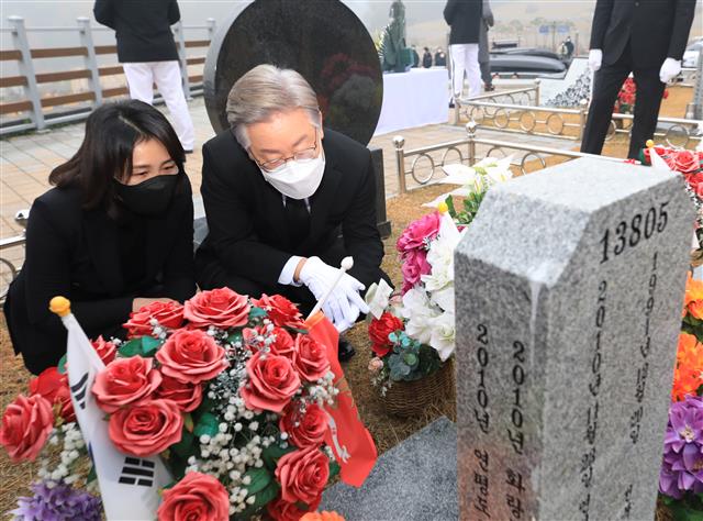 이재명(오른쪽) 더불어민주당 대선후보와 부인 김혜경씨가 21일 국립대전현충원 연평도 포격 전사자 묘역을 함께 참배한 뒤 비석을 살피고 있다. 대전 뉴스1