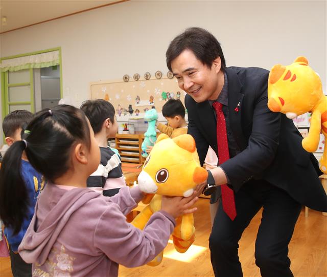 서철모 화성시장이 아이돌봄센터를 찾아 어린이에게 인형을 전달하고 있다.