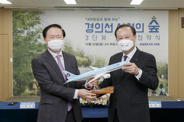 서울 마포구의 친환경 정책에 동참하는 기업도 늘고 있다. 유 구청장(오른쪽)이 우기홍 대한항공 대표이사 사장과 ‘경의선 선형의 숲’ 3단계 조성 사업 업무 협약을 맺은 뒤 기념 촬영을 하고 있다.<br>마포구 제공