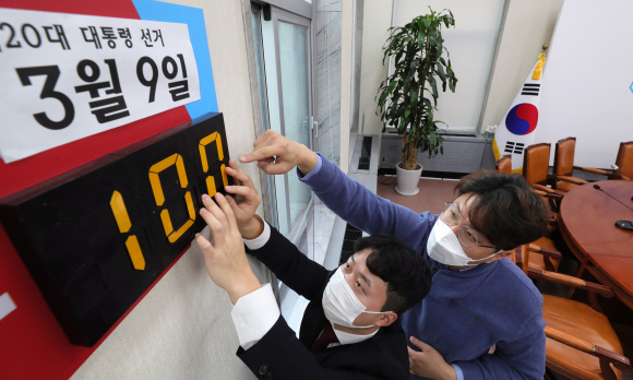 내년 3월9일 치러질 대통령선거를 100일 앞둔 29일 국회 국민의힘 최고위원회의 회의실에서 당직자들이 선거 D-DAY 알림판을 조정하고 있다. 2021. 11. 29  김명국 선임기자 daunso@seoul.co.kr