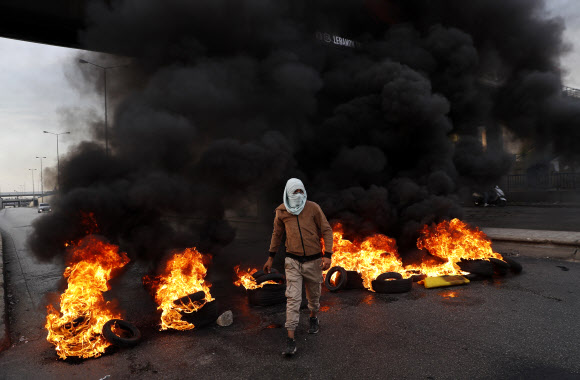 불타는 티르를 지나치는 시위자