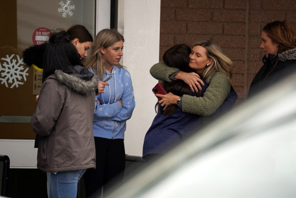 30일(현지시간) 미국 미시간주 오클랜드 옥스퍼드 고교에서 자녀를 만나 포옹하는 어머니. AP