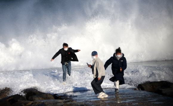 동해상에 풍랑특보가 내려진 1일 강원 강릉의 한 해안 방파제에서 관광객들이 높은 파도가 이는 가운데 사진을 찍다 몸을 피하고 있다. 2021.12.1 연합뉴스