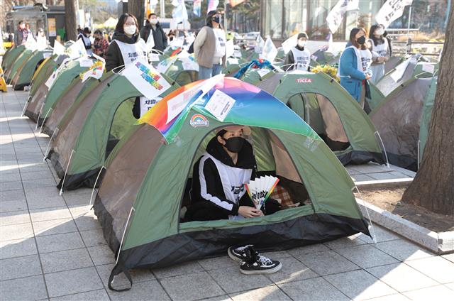 2021 차별금지법 연내제정 쟁취 농성단 관계자들이 4일 서울 여의도 국민은행 앞에서 열린 ‘2021 차별금지법 제정 촉구 집중 농성’에 참석해 텐트를 치고 있다. 해당 관계자들은 ‘개인 농성장’ 마련을 목적으로 이날 499개의 텐트를 치고 농성을 진행했다. 2021.12.4  뉴스1