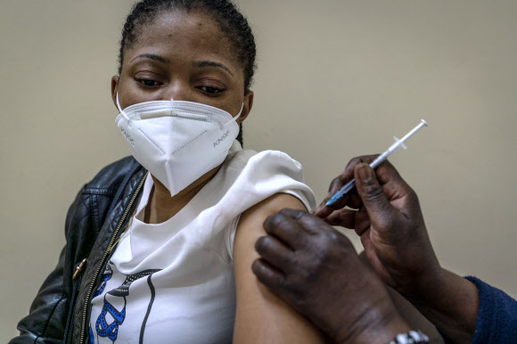 오미크론 확산 속 접종받는 남아공 여성  코로나19 오미크론 변이가 확산 중인 남아프리카공화국의 수도 요하네스버그의 병원에서 6일(현지시간) 한 여성이 백신 접종을 받고 있다. 2021.12.6 <br>AP 연합뉴스