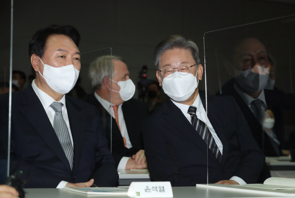 더불어민주당 이재명 대선 후보와 국민의힘 윤석열 대선 후보가 9일 서울 마포구 연세대 김대중도서관에서 열린 ‘김대중 대통령 노벨평화상 수상 21주년 기념식 및 학술회의’에 참석해 대화하고 있다.2021. 12. 9 정연호 기자 tpgod@seoul.co.kr