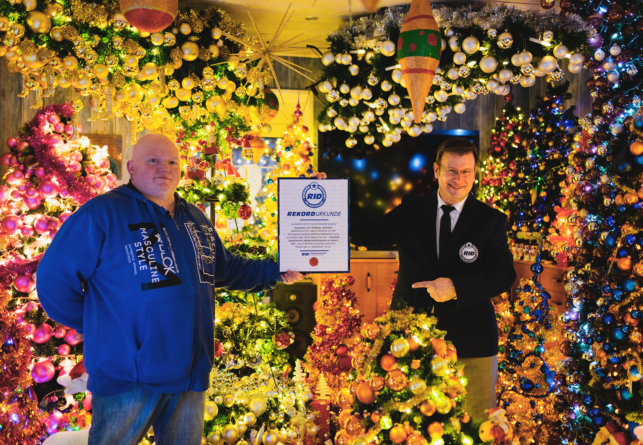 집 안에 420그루의 크리스마스트리를 장식해 ‘한 곳에 많은 트리 장식하기’ 부문에서 세계 기록을 세운 토마스 제로미(왼쪽)가 올라프 쿠첸베커 독일기록원(RID) 담당자로부터 기록 인증서를 받고 있다. 2021.12.9  독일기록원 제공