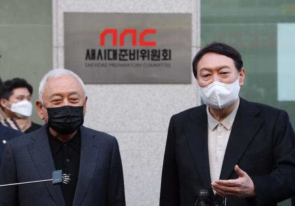 윤석열 국민의힘 대선 후보와 김한길 새시대준비위원회 위원장이 12일 오후 서울 여의도에 마련된 새시대준비위원회 사무실 앞에서 열린 현판식 후 기자들의 질문에 답변하고 있다. 2021. 12. 12  정연호 기자 tpgod@seoul.co.kr