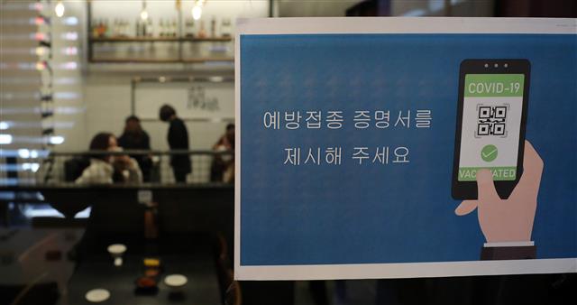 방역패스의 계도기간이 끝나고 의무화가 시작된 13일 서울시내의 한 식당에 예방접종 증명서 제시를 안내하는 안내문이 붙어 있다. 2021.12.13 뉴스1