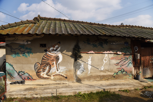 안성 복거마을의 한 농가 벽면에 그려진 ‘담배 피우는 호랑이’ 벽화.