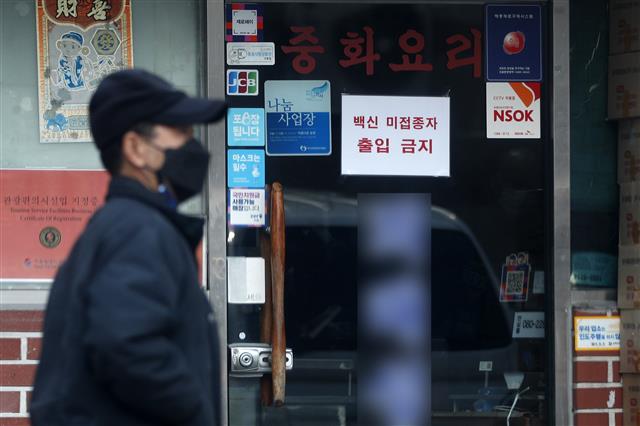 16일 서울시내 한 식당에 ‘백신 미접종자 출입 금지’ 안내문이 붙어있다. 오는 18일부터 사적모임 인원 최대 4명, 식당·카페와 유흥시설 등은 오후 9시까지 영업시간을 제한하는 방역 강화 조치가 시행되는 가운데 미접종자는 혼자서 이용하거나 포장·배달만 허용된다. 2021.12.16  뉴스1