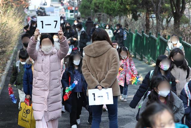 국내 코로나19 확산세가 거세지면서 전면등교 시행도 한 달을 못 채우고 중단됐다. 교육부는 16일 정부 거리두기 강화 조치에 따라 “지역 감염 위험이 큰 수도권 지역 모든 학교와 비수도권 과대학교?과밀학급을 중심으로 학교밀집도를 3분의 2 수준으로 조정한다”고 밝혔다. 지난달 22일 전국에서 전면등교가 시행된 지 24일 만이다. 16일 서울의 한 초등학교에서 아이들이 하교하고 있다. 2021.12.16  뉴스1
