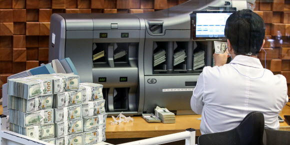 한국은행이 미국 연방준비제도이사회(연준)와 체결한 한시적 통화스와프계약이 예정대로 이달 31일 계약만기 일에 종료될 예정이라고 밝힌 16일 오후 서울 중구 하나은행 본점 위변조방지센터에서 직원이 달러를 감별하고 있다. 한은 관계자는 종료 배경에 대해 “통화스와프계약 체결 이후 국내외 금융·경제 상황이 위기에서 벗어나 안정을 유지하고 있기 때문”이라고 설명했다. 한·미 통화스와프계약이 종료되더라도 최근의 금융·외환시장 상황, 강화된 외화유동성 대응 역량 등을 고려할 때 국내 외환시장에 미치는 영향은 크지 않다는 게 한은의 분석이다. 2021.12.16  연합뉴스