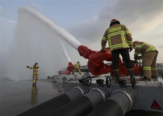 16일 오후 울산 울주군 온산읍 처용리 해안도로 일원에서 ‘대용량포 방사시스템’ 구축 장비 시연회가 열리고 있다.  울산에 전국 최초로 구축된 대용량포 방사시스템은 대형 유류저장탱크의 화재를 조기에 진압할 수 있으며, 대구경(300㎜) 소방호스 2.5㎞를 전개해 분당 최대 7만5000ℓ(4만5000ℓ 1대, 3만 리터 1대)를 방수할 수 있다. 방사거리는 최대 110m이다. 대용량포 방사시스템 도입은 지난 2018년 10월 경기 고양저유소 원유탱크 화재 당시 128억원의 재산피해가 발생해 진압까지 17시간 이상 장시간 소요된 것을 계기로 추진됐다. 2021.12.16 뉴스1