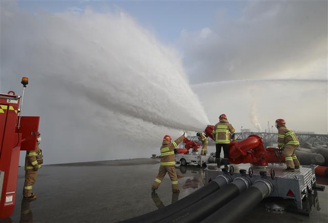 16일 오후 울산 울주군 온산읍 처용리 해안도로 일원에서 ‘대용량포 방사시스템’ 구축 장비 시연회가 열리고 있다.  울산에 전국 최초로 구축된 대용량포 방사시스템은 대형 유류저장탱크의 화재를 조기에 진압할 수 있으며, 대구경(300㎜) 소방호스 2.5㎞를 전개해 분당 최대 7만5000ℓ(4만5000ℓ 1대, 3만 리터 1대)를 방수할 수 있다. 방사거리는 최대 110m이다.  대용량포 방사시스템 도입은 지난 2018년 10월 경기 고양저유소 원유탱크 화재 당시 128억원의 재산피해가 발생해 진압까지 17시간 이상 장시간 소요된 것을 계기로 추진됐다. 2021.12.16  뉴스1