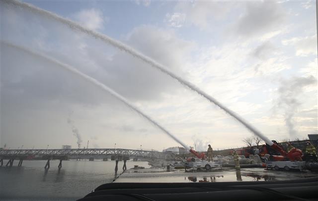 16일 오후 울산 울주군 온산읍 처용리 해안도로 일원에서 ‘대용량포 방사시스템’ 구축 장비 시연회가 열리고 있다.  울산에 전국 최초로 구축된 대용량포 방사시스템은 대형 유류저장탱크의 화재를 조기에 진압할 수 있으며, 대구경(300㎜) 소방호스 2.5㎞를 전개해 분당 최대 7만5000ℓ(4만5000ℓ 1대, 3만 리터 1대)를 방수할 수 있다. 방사거리는 최대 110m이다.  대용량포 방사시스템 도입은 지난 2018년 10월 경기 고양저유소 원유탱크 화재 당시 128억원의 재산피해가 발생해 진압까지 17시간 이상 장시간 소요된 것을 계기로 추진됐다. 2021.12.16 뉴스1