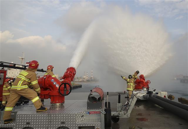16일 오후 울산 울주군 온산읍 처용리 해안도로 일원에서 ‘대용량포 방사시스템’ 구축 장비 시연회가 열리고 있다.  울산에 전국 최초로 구축된 대용량포 방사시스템은 대형 유류저장탱크의 화재를 조기에 진압할 수 있으며, 대구경(300㎜) 소방호스 2.5㎞를 전개해 분당 최대 7만5000ℓ(4만5000ℓ 1대, 3만 리터 1대)를 방수할 수 있다. 방사거리는 최대 110m이다.  대용량포 방사시스템 도입은 지난 2018년 10월 경기 고양저유소 원유탱크 화재 당시 128억원의 재산피해가 발생해 진압까지 17시간 이상 장시간 소요된 것을 계기로 추진됐다. 2021.12.16  뉴스1