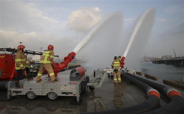 16일 오후 울산 울주군 온산읍 처용리 해안도로 일원에서 ‘대용량포 방사시스템’ 구축 장비 시연회가 열리고 있다.  울산에 전국 최초로 구축된 대용량포 방사시스템은 대형 유류저장탱크의 화재를 조기에 진압할 수 있으며, 대구경(300㎜) 소방호스 2.5㎞를 전개해 분당 최대 7만5000ℓ(4만5000ℓ 1대, 3만 리터 1대)를 방수할 수 있다. 방사거리는 최대 110m이다.  대용량포 방사시스템 도입은 지난 2018년 10월 경기 고양저유소 원유탱크 화재 당시 128억원의 재산피해가 발생해 진압까지 17시간 이상 장시간 소요된 것을 계기로 추진됐다. 2021.12.16  뉴스1
