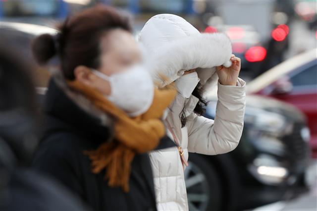서울 지역 아침 최저기온이 영하 5도까지 떨어진 17일 서울 종로구 광화문네거리에서 두꺼운 겨울 외투를 챙겨 입은 시민들이 출근길 발걸음을 재촉하고 있다. 2021.12.17  뉴스1