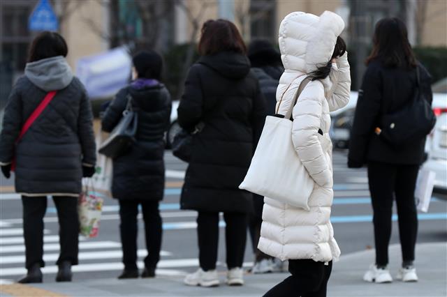 서울 지역 아침 최저기온이 영하 5도까지 떨어진 17일 서울 종로구 광화문네거리에서 두꺼운 겨울 외투를 챙겨 입은 시민들이 출근길 발걸음을 재촉하고 있다. 2021.12.17 뉴스1