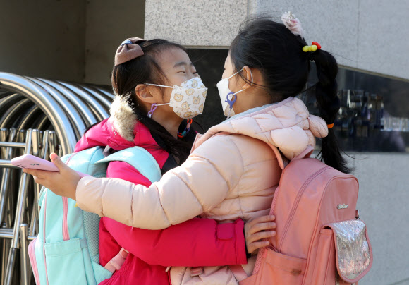 경남지역 일부 학교가 조기방학에 들어간 17일 오전 경남 양산시 한 초등학교 교문 앞에서 학생들이 인사하고 있다. 2021.12.17 연합뉴스