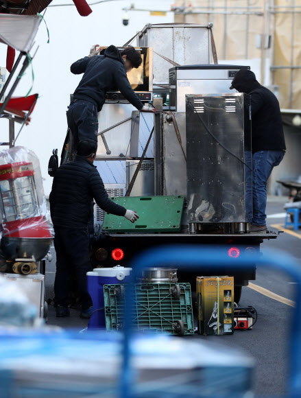 정부가 코로나19 특별방역 대책으로 매출이 감소한 소상공인 320만명에게 100만원 상당의 방역지원금을 지급하기로 했다.  이·미용업, 키즈카페 등 인원·시설 이용 제한업종 12만곳은 소상공인 손실보상 대상에 새로 포함된다.  정부는 이런 내용 등을 담은 방역지원금 및 손실보상·지원 확대 방안을 17일 발표했다.  사진은 이날 서울 중구 황학동주방가구거리에서 폐업한 가게에서 나온 집기류 등을 내리고 있다. 2021.12.17 연합뉴스