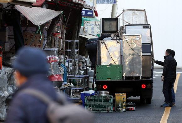 정부가 코로나19 특별방역 대책으로 매출이 감소한 소상공인 320만명에게 100만원 상당의 방역지원금을 지급하기로 했다.  이·미용업, 키즈카페 등 인원·시설 이용 제한업종 12만곳은 소상공인 손실보상 대상에 새로 포함된다.  정부는 이런 내용 등을 담은 방역지원금 및 손실보상·지원 확대 방안을 17일 발표했다.  사진은 이날 서울 중구 황학동주방가구거리에서 폐업한 가게에서 나온 집기류 등을 내리고 있다. 2021.12.17 연합뉴스