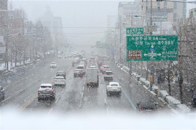 17일 오후 광주 서구 내방동 일대 한 도로에서 내리는 눈으로 자동차들이 ‘거북이 운전’을 하고 있다. 2021.12.17  뉴스1