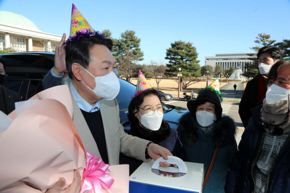 생일을 맞은 국민의힘 윤석열 대선 후보가 18일 오전 국회 의원회관 앞에서 지지자들로부터 꽃다발과 케이크를 받고 있다. 2021.12.18 연합뉴스 