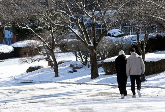 18일 오전 광주 북구 오치공원에서 시민들이 눈길을 걸어가고 있다. 2021.12.18  연합뉴스