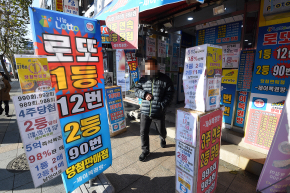 정부가 2022년도 복권 발행 액수를 올해보다 7.1% 증액한 6조 6515억원으로 의결한 가운데 19일 한 남성이 서울 시내 한 복권 판매점에서 나오고 있다. 오장환 기자 5zzang@seoul.co.kr