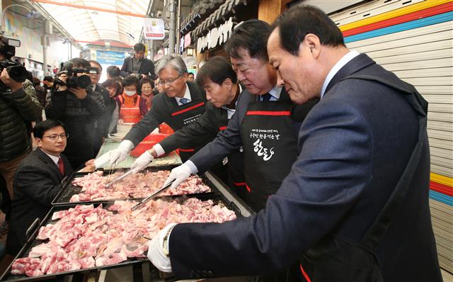 삼겹살 축제가 열리고 있는 삼겹살거리를 방문한 한범덕(오른쪽 두 번째) 청주시장 등이 커다란 불판 위에서 삼겹살을 굽고 있다.<br>청주시 제공