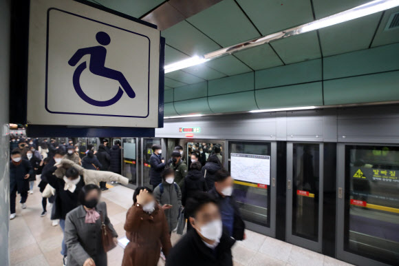 장애인단체 시위에 지하철 5호선 운행이 지연되고 있는 20일 오전 서울 광화문역에서 시민들이 열차에서 내려 승강장을 나서고 있다. 2021.12.20 연합뉴스