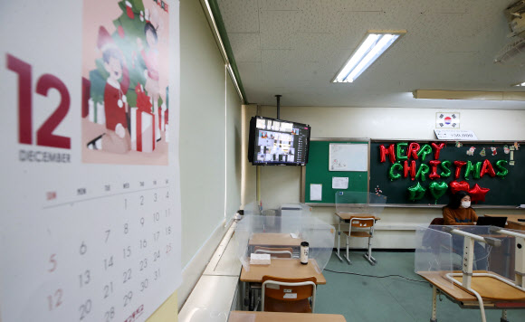 수도권 모든 학교의 전면등교가 중단되고 등교수업과 원격수업이 병행 실시된 20일 오전 경기도 수원시 화홍중학교 3학년 교실에서 선생님이 원격수업을 하고 있다. 2021.12.20 연합뉴스