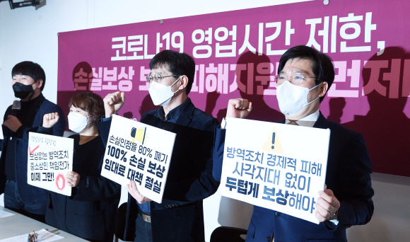 20일 서울 종로구 참여연대에서 열린 ‘코로나19 영업시간 제한, 손실보상 보완·피해지원이 먼저다’ 기자회견에서 참석자들이 구호를 외치고 있다. 2021. 12. 20 박윤슬 기자 seul@seoul.co.kr