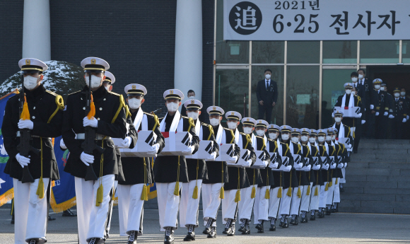 20일 서울 동작구 국립서울현충원 현충관에서 열린 2021년 6·25 전사자 합동봉안식에서 장병들이 영현봉송을 하고 있다. 이번에 봉안되는 370구는 국방부 유해발굴감식단과 육군, 해병대 31개 사·여단급 부대가 지난 3월부터 11월 말까지 강원도 철원?인제, 경기도 파주?연천 등 6·25전쟁 격전지 41곳에서 발굴했다.  2021. 12. 20 안주영 전문기자 jya@seoul.co.kr