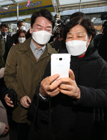 국민의당 안철수 대선후보가 부인 김미경 씨와 함께 20일 오후 대구 중구 서문시장을 찾아 시민들과 셀카를 찍고 있다. 2021.12.20 연합뉴스