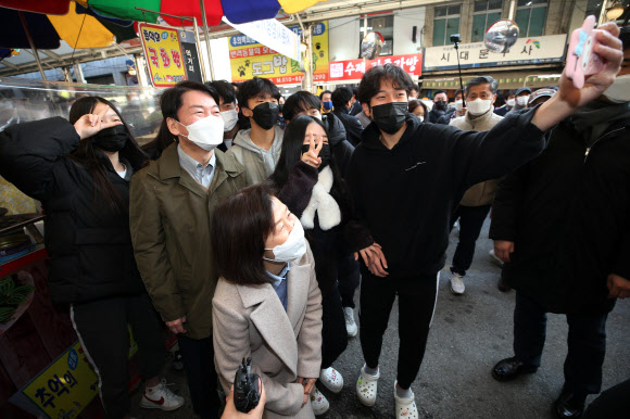 국민의당 안철수 대선후보가 부인 김미경 씨와 함께 20일 오후 대구 중구 서문시장을 찾아 시민들과 셀카를 찍고 있다. 2021.12.20 연합뉴스