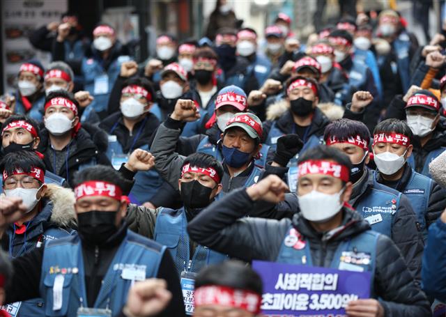 20일 오후 서울 중구 CJ대한통운 본사 앞에서 열린 CJ대한통운 전국대표자 총파업 선포대회에서 참가자들이 구호를 외치고 있다. CJ 대한통운 택배노조가 오는 28일부터 무기한 총파업에 나선다. 택배노동자들은 CJ대한통운이 택배노동자들의 과로사를 막기 위해 국민들이 합의해 준 택배요금 인상액의 4800억원 중 3500억원을 자기 초과 이윤으로 가져가고 있으며 저상탑차 문제에 대한 해결 의지가 없다고 주장했다. 2021.12.20   뉴스1