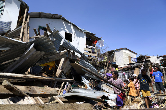 지난 18일(현지시간) 필리핀 중부 세부주 탈리사이에서 태풍 라이로 피해를 입은 주민들이 파괴된 집의 잔해를 헤치고 소지품을 찾고 있다. 세부 AP 연합뉴스
