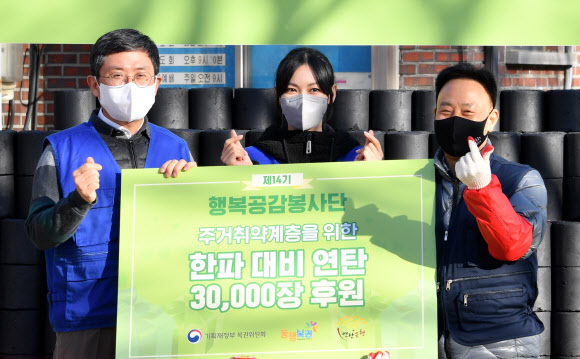 안도걸 기획재정부 차관(왼쪽)이 22일 서울 성북구 정릉3동 일대에서 진행된 제14기 행복공감봉사단 봉사활동 기념행사에서 복권위원회 홍보대사 겸 행복공감봉사단장인 배우 김소연(가운데), 연탄은행 관계자와 연탄 후원 기념 촬영을 하고 있다. 2021.12.22  기획재정부 제공