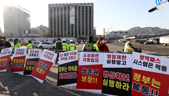 22일 오후 서울 광화문시민열린마당에서 열린 ‘코로나19 대응 전국자영업자비상대책위원회(자영업비대위) 정부 방역 대책 반대 총궐기 대회’에서 집회 시작 전 경찰 펜스에 팻말이 걸려 있다. 2021.12.22 연합뉴스