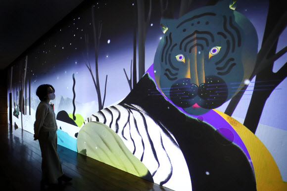 22일 서울 종로구 국립민속박물관에서 열린 특별전 ‘호랑이 나라’를 찾은 관람객이 작품을 살펴보고 있다. 내년 임인년 호랑이해를 맞아 한국 문화에 녹아 있는 호랑이 관련 상징과 문화상을 조명하는 이번 전시는 맹호도를 비롯한 유물과 영상 70여 점을 내년 3월 1일까지 만날 수 있다. 2021.12.22 연합뉴스