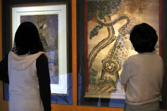 22일 서울 종로구 국립민속박물관에서 열린 특별전 ‘호랑이 나라’를 찾은 관람객들이 작호도를 살펴보고 있다. 내년 임인년 호랑이해를 맞아 한국 문화에 녹아 있는 호랑이 관련 상징과 문화상을 조명하는 이번 전시는 맹호도를 비롯한 유물과 영상 70여 점을 내년 3월 1일까지 만날 수 있다. 2021.12.22 연합뉴스