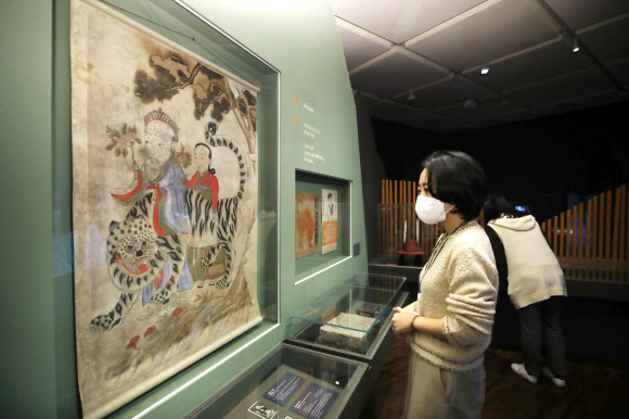 22일 서울 종로구 국립민속박물관에서 열린 특별전 ‘호랑이 나라’를 찾은 관람객들이 산신도를 살펴보고 있다. 내년 임인년 호랑이해를 맞아 한국 문화에 녹아 있는 호랑이 관련 상징과 문화상을 조명하는 이번 전시는 맹호도를 비롯한 유물과 영상 70여 점을 내년 3월 1일까지 만날 수 있다. 2021.12.22 연합뉴스