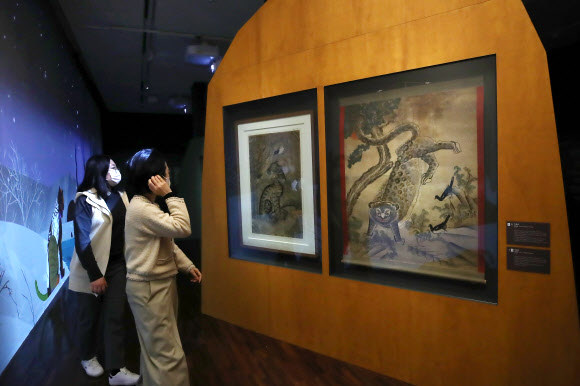 22일 서울 종로구 국립민속박물관에서 열린 특별전 ‘호랑이 나라’를 찾은 관람객들이 작호도를 살펴보고 있다. 내년 임인년 호랑이해를 맞아 한국 문화에 녹아 있는 호랑이 관련 상징과 문화상을 조명하는 이번 전시는 맹호도를 비롯한 유물과 영상 70여 점을 내년 3월 1일까지 만날 수 있다. 2021.12.22 연합뉴스