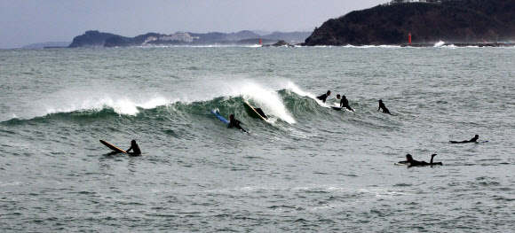 22일 강원 양양지역의 한 해변에서 서퍼들이 파도타기를 즐기고 있다. 2021.12.22 연합뉴스