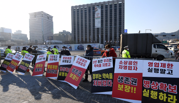 전국자영업자비상대책위원회가 22일 서울 광화문에서 정부의 방역대책에 반대하는 집회를 하면서 피켓을 세우고 있다.  오장환 기자 5zzang@seoul.co.kr