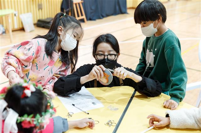 지난 16일 인천 강화군 교동초등학교 강당에서 열린 ‘어쩌다 귀농’ 수업에서 이 학교 아이들이 직접 그림을 그려 넣은 조롱박으로 열쇠고리를 만들고 있다.  한국문화예술교육진흥원 제공
